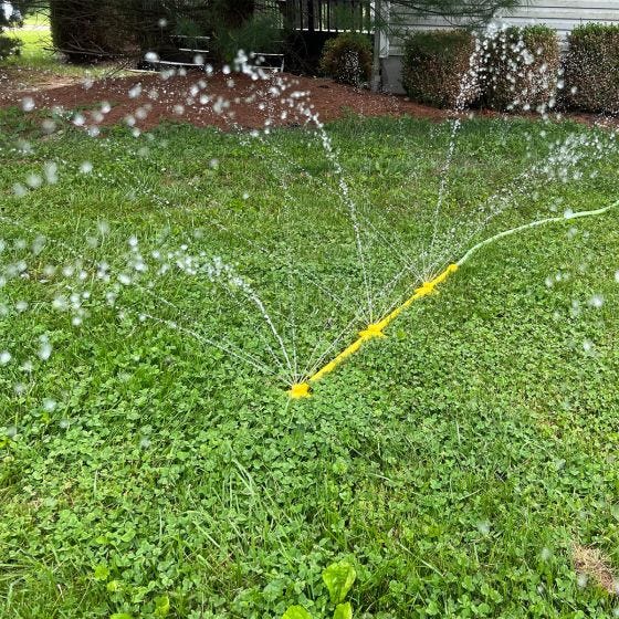 Mower cleaner spraying in grass